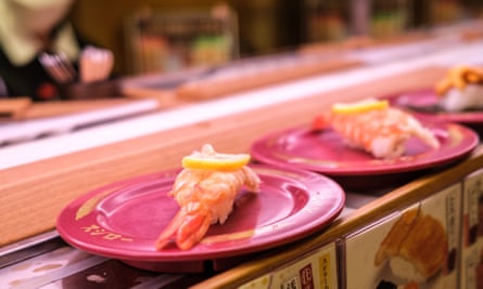 Assiettes de sushis sur un tapis roulant dans un restaurant de la chaîne de sushis à Tokyo