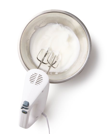 A whisk in a bowl of egg whites