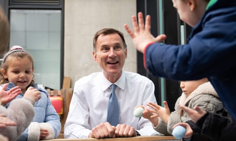 Jeremy Hunt, smiling, surrounded by nursery age children.