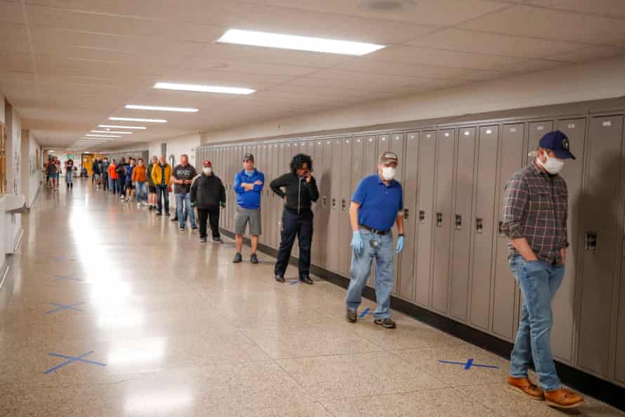 People wait in line to vote in a Democratic presidential primary election outside the Hamilton High School in Milwaukee, Wisconsin, on April 7, 2020.