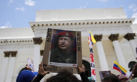 A supporter of Maduro holds up a poster of Chávez in Caracas. The country has faced increasing political turmoil.