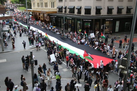 Protestors carrying the Palestinian flag through the streets of Sydney on Saturday.