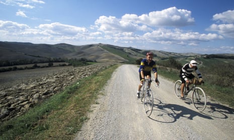 Two cyclists amid the countryside in Gaiole, Chianti, Tuscany, Italy.