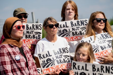 Protesters hold signs opposing data centers outside