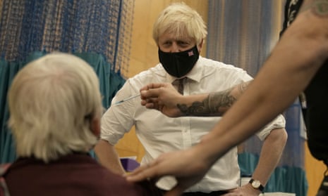 Boris Johnson watches as 88-year-old Nitza Sarner receives a Pfizer booster vaccination.