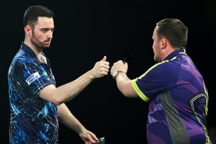 Luke Humphries and Luke Littler fist-bump during a match