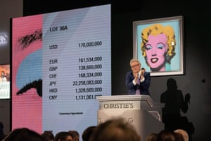A Christie’s auctioneer claps after ending the auction of Shot Sage Blue Marilyn by Andy Warhol, which sold for $170m (£140m) in New York, US