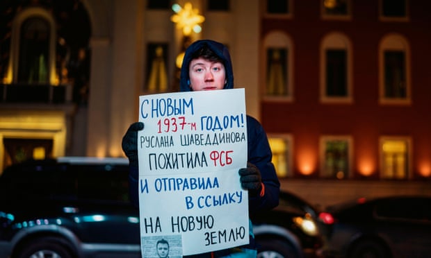 A man holds a poster reading ‘Happy New Year 1937, Ruslan Shaveddinov has been kidnapped by the FSB (security service) and exiled to Novaya Zemlya’ during a protest in central Moscow.