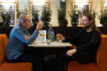 Philip and Carl chatting and eating at a restaurant table