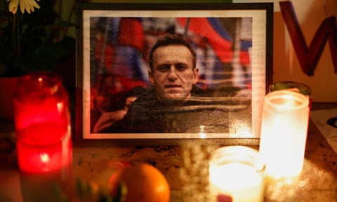 Candles burn next to a portrait of Alexei Navalny at a vigil in Paris after his death.