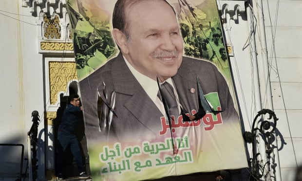 Algerian demonstrators tear down a large billboard depicting the country’s president, Abdelaziz Bouteflika, on 22 February
