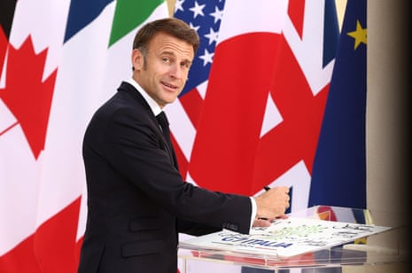 French President Emmanuel Macron signs a guest book at the G7.