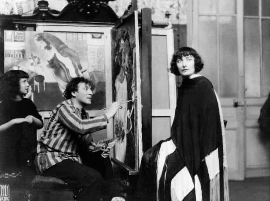Chagall paints his wife, Bella, at his Paris atelier as his daughter, Ida, watches on. Behind him is Birthday.