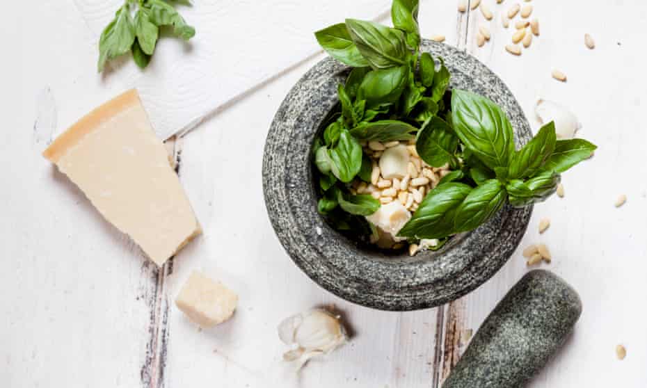 Preparing pesto alla genovese with a mortar.