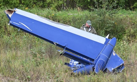 A Russian serviceman inspects a part of the crashed jet near the village of Kuzhenkino