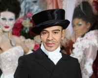 A man in a top hat poses with models