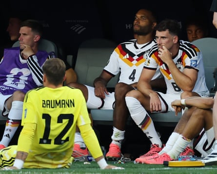 Germany's players, including Oliver Baumann, Jonathan Tah and Leon Goretzka, sit in the dugout contemplating their loss on Paraguay to penalties in the last 32 of the 2026 World Cup.