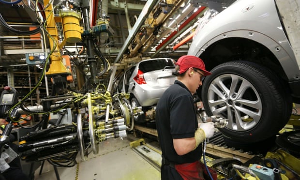 A worker produces a car at Nissan’s assembly plant