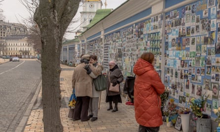 At Kyiv’s wall of remembrance friends embrace Liudmyla (left) whose son was killed fighting Russian troops