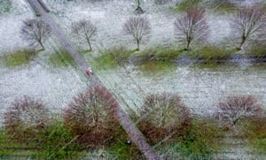 Frankfurt, Germany. People walk though a park as snow falls