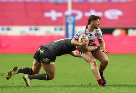 Wigan's Jack Farrimond is tackled by Leeds' Cameron Smith