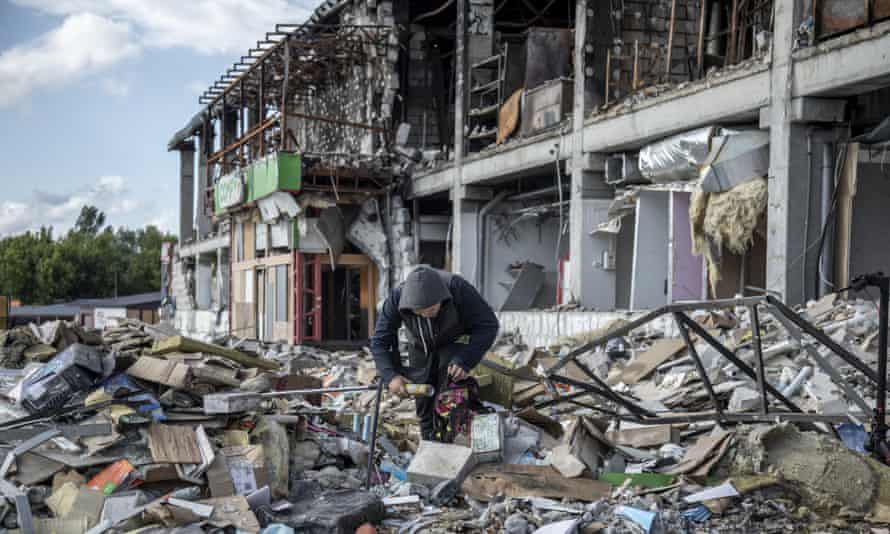 A young boy collects goods from the debris of a shopping centre that was destroyed in Irpin in March.