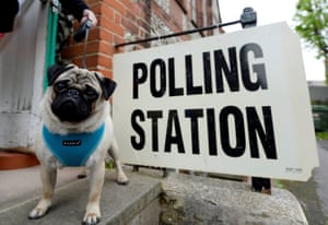 A voter arrives with a dog at a polling station in Brighton