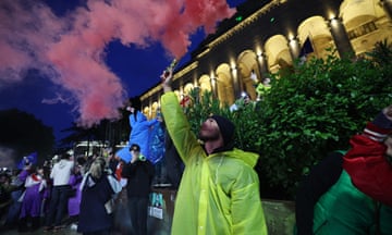 A protester holds a flare during a rally against the controversial 'foreign influence' bill in Tbilisi