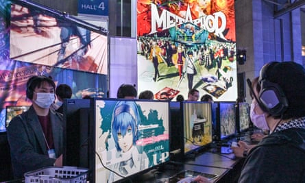 People sit in front of monitors playing the video game Metaphor: ReFantazio at the Tokyo Game Show.