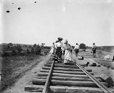 Cherokee Nation women in western clothing walk along the track of a railway under construction