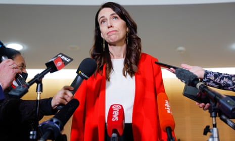 Jacinda Ardern surrounded by microphones and tape recorders at a media conference