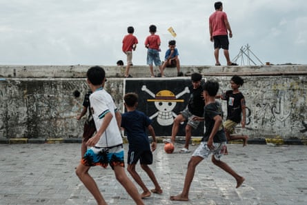 A pirate flag from the Japanese anime One Piece is painted as graffiti on a seawall, as boys play football nearby, in Cilincing, North Jakarta, on 20 September 2025.