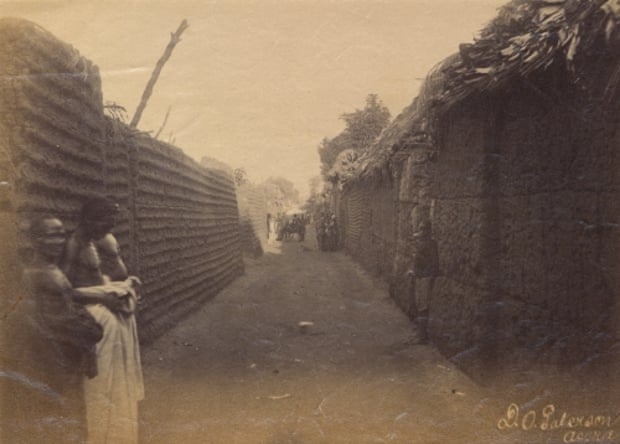 View along a street in the royal quarter of Benin City, from 1897.
