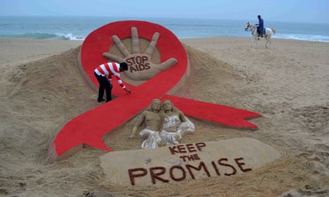 Indian sand artist Sudersan Pattnaik gives the final touches to a sand sculpture on the eve of World AIDS Day