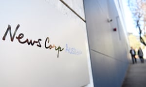 Pedesrians walk past the News Corp Australia office in Sydney