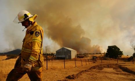 A Rural Fire Service firefighter views a flank of a fire on 11 January in Tumburumba, Australia.