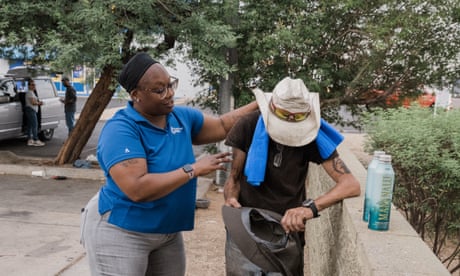 City of Phoenix caseworker Mia Stanford puts a cooling towel on a man.