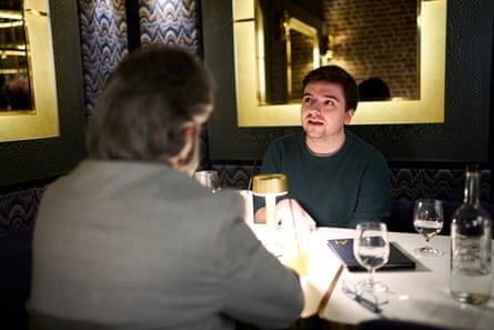 Two men facing each other across a restaurant table