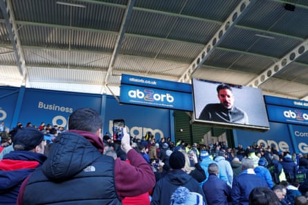 January 20: Huddersfield Town fans watch a message from recently departed manager David Wagner on the scoredboard at half time against Manchester City.