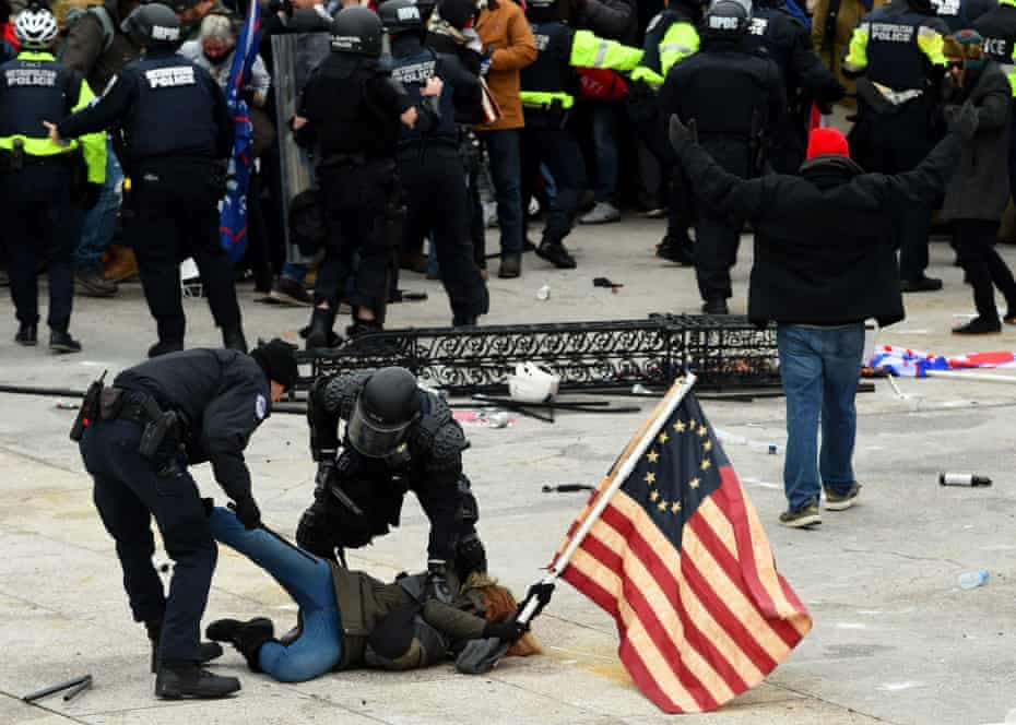 Police detain a person as supporters of Donald Trump riot at the US Capitol on 6 January.