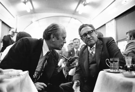 two men speak with each other in a train
