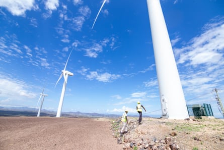 Three huge wind turbines against a blue sky