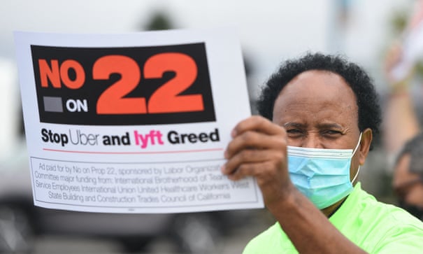 A driver holds up a sign supporting a no vote on Prop 22 in Oakland last year. The ruling sets up a fight that could likely end up in California’s supreme court. Photograph: Josh Edelson/AFP/Getty Images