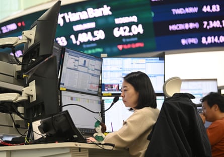 A currency dealer monitors exchange rates at her desk in South Korea