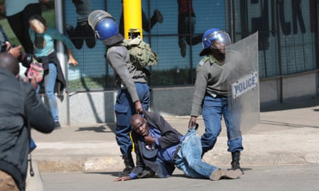 Zimbabwe Republic Police drag away a protester in Harare