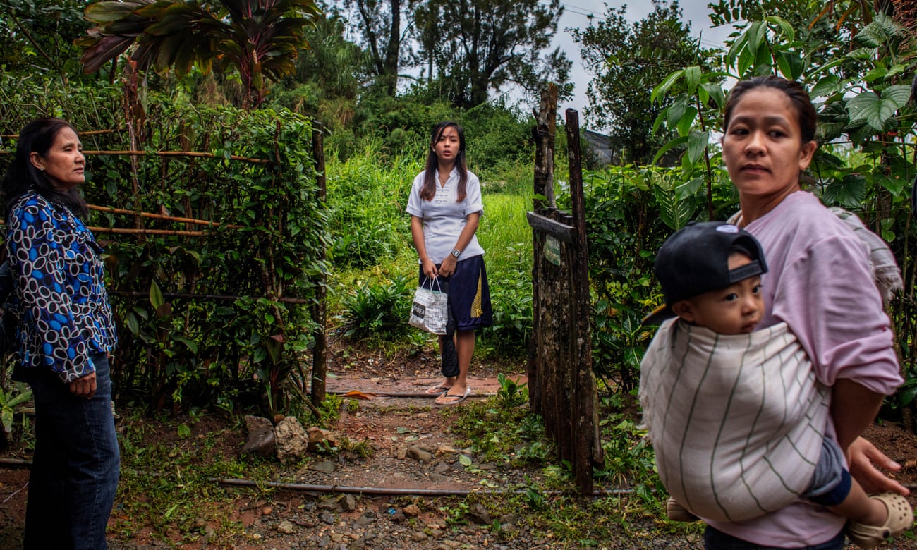 Tublay, Philippines, August 2019: Three generations of women gather at the entrance to their house. Donna is absent.