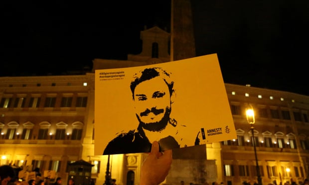 A man holding a sign depicting Giulio Regeni during a vigil in Rome. 