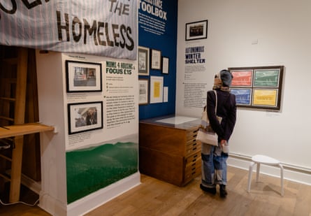 A woman looks at a wall-mounted display in an exhibition about homelessness.