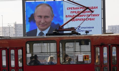 A tram in Belgrade goes past a billboard with an image of Vladimir Putin