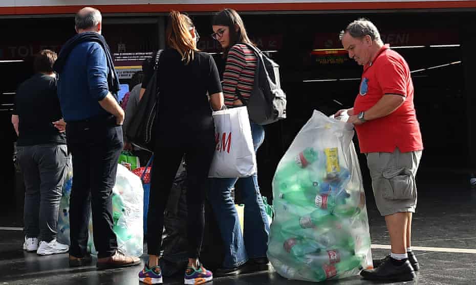 Italians take plastic bottles to a reverse vending machine at a metro station in Rome.